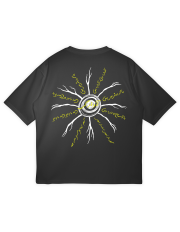 The back of a black oversized t-shirt featuring a large graphic of a sun-like root system. White branches radiate from a central circle, with lines of yellow Urdu calligraphy from the 'Awaara Hon' song written along the branches.