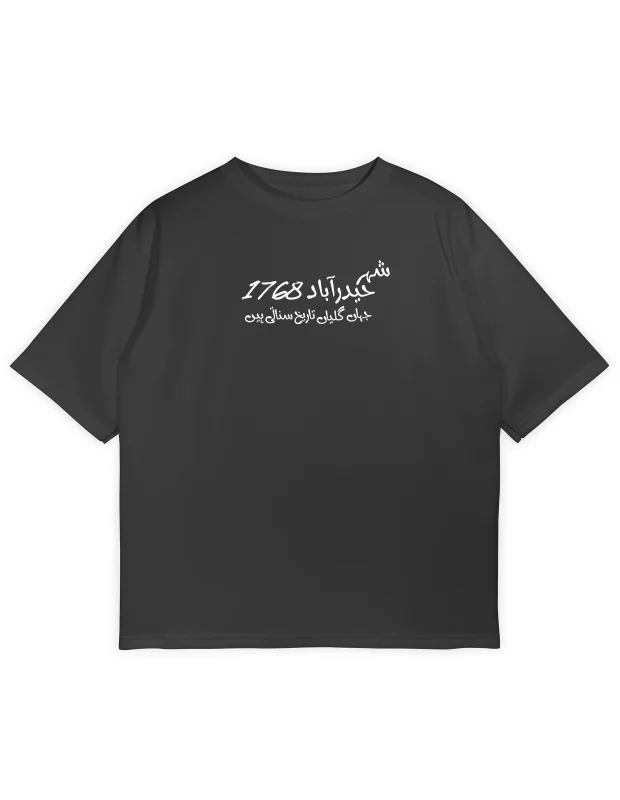 Oversized black streetwear t-shirt with white Urdu calligraphy on the chest reading "شہر حیدرآباد 1768"